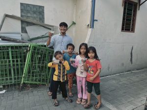 Seorang mahasiswa Patani bersama anak-anak warga menunjukkan takjil yang diterima di kawasan Banguntapan.